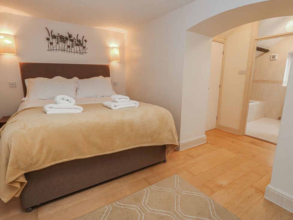 A bedroom with a bed and towels at The Grain Store in Weymouth
