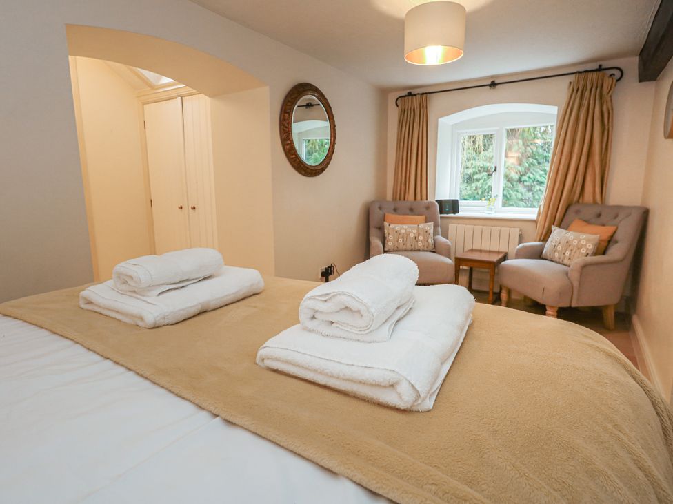 A bedroom with a bed and armchairs at The Grain Store in Weymouth