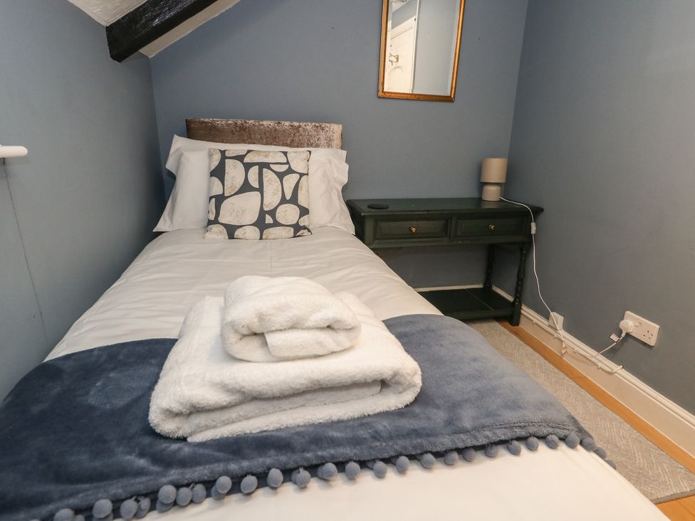 A bedroom with a single bed and a side table at The Grain Store in Weymouth