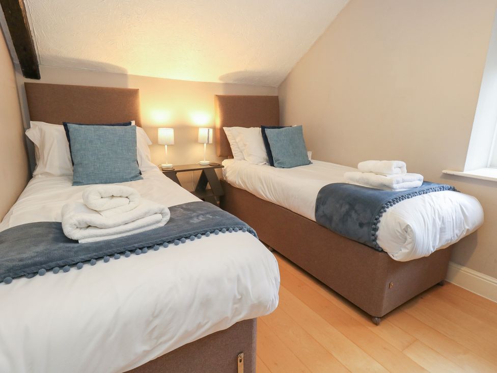 A bedroom with two single beds and bedside lamps at The Grain Store in Weymouth