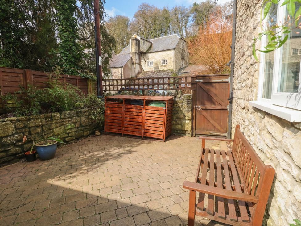 A garden with a bench and storage unit at The Grain Store in Weymouth