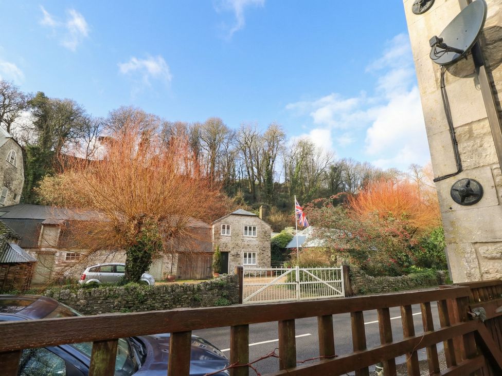 A view of a garden with a house and trees at The Grain Store in Weymouth