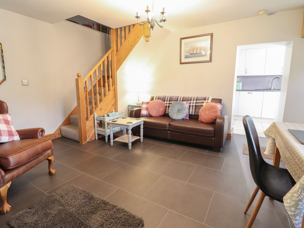 A living room with a sofa and a staircase at Bridgeway House in Blaenau Ffestiniog
