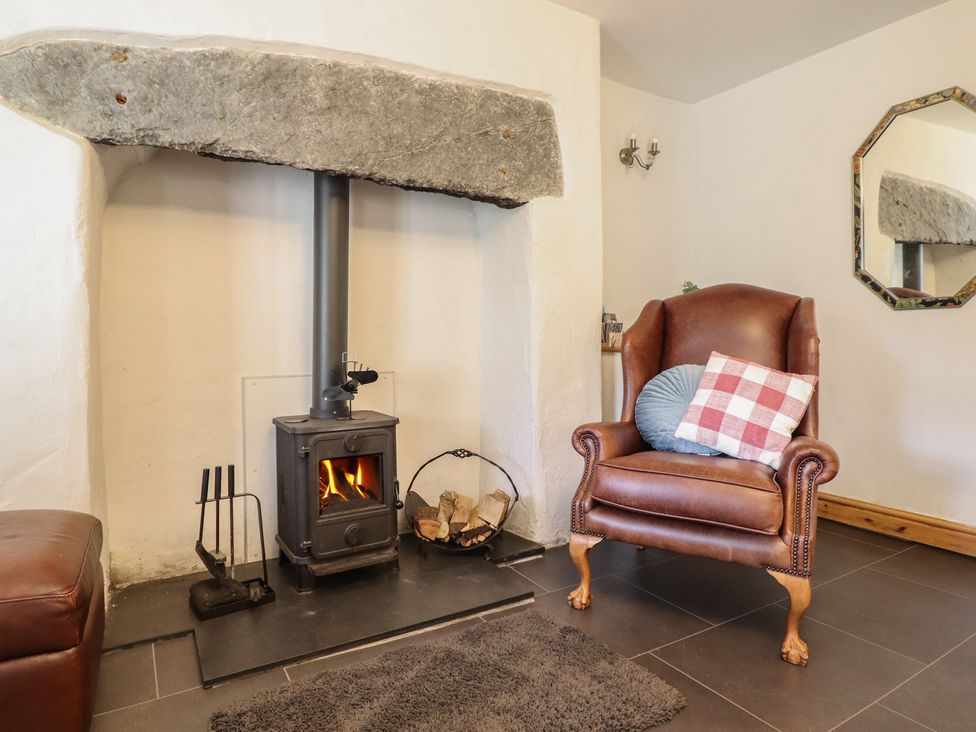A living room with a fireplace and armchair at Bridgeway House in Blaenau Ffestiniog