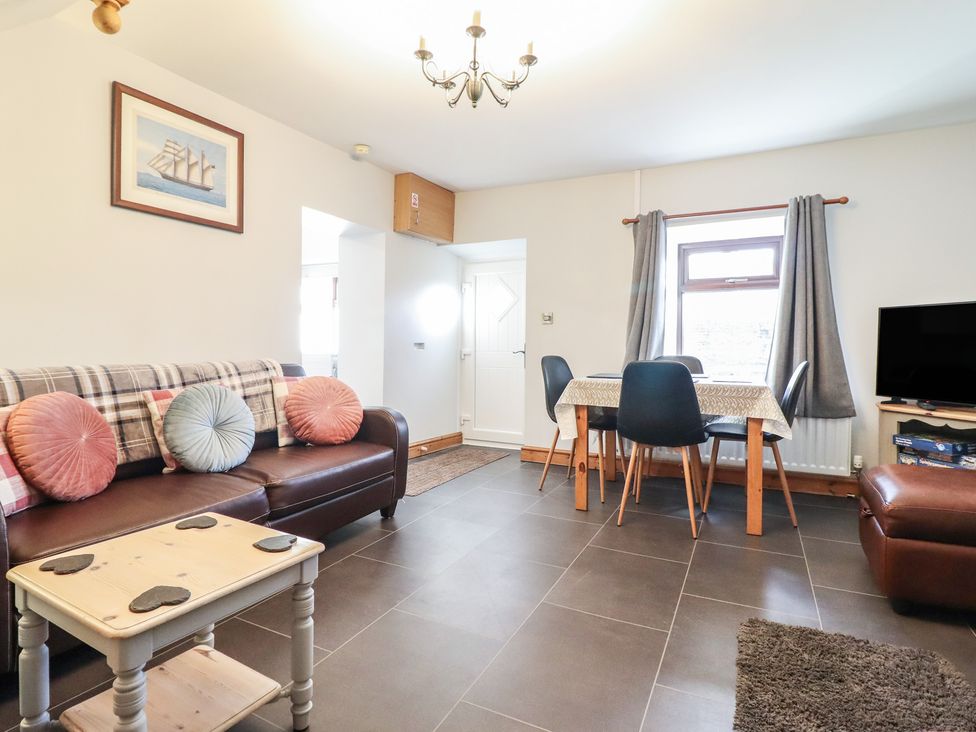 A living room with a sofa and dining table at Bridgeway House in Blaenau Ffestiniog