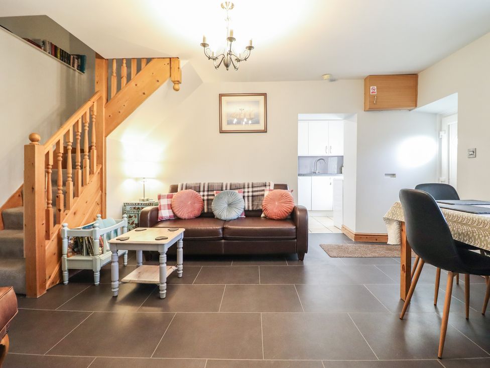 A living room with a sofa and staircase at Bridgeway House in Blaenau Ffestiniog