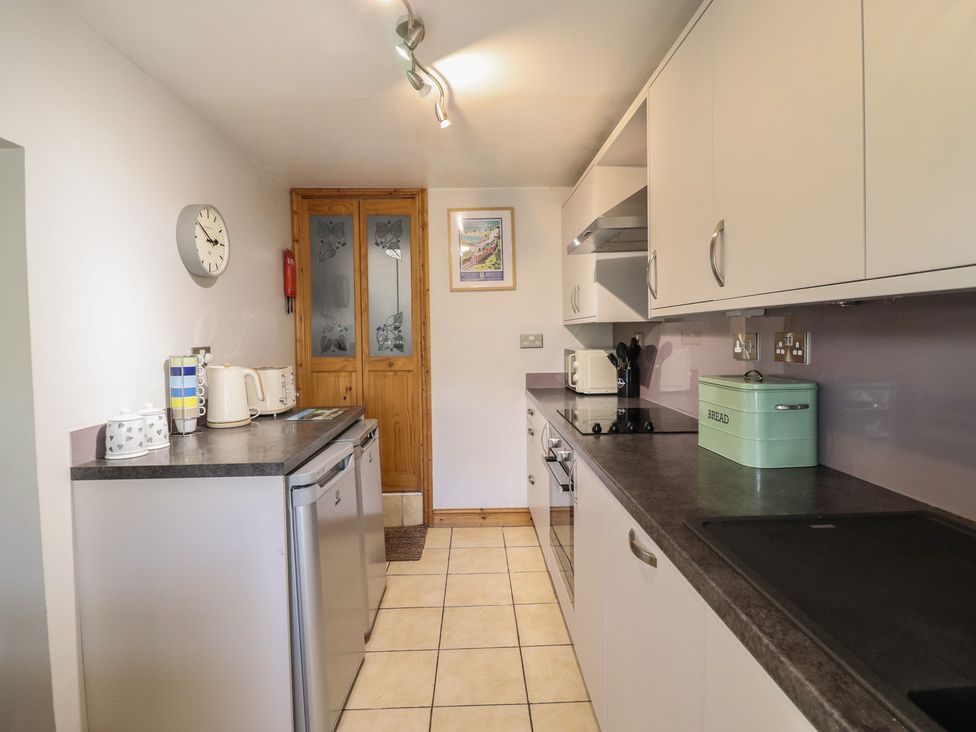 A kitchen with appliances and cabinets at Bridgeway House in Blaenau Ffestiniog