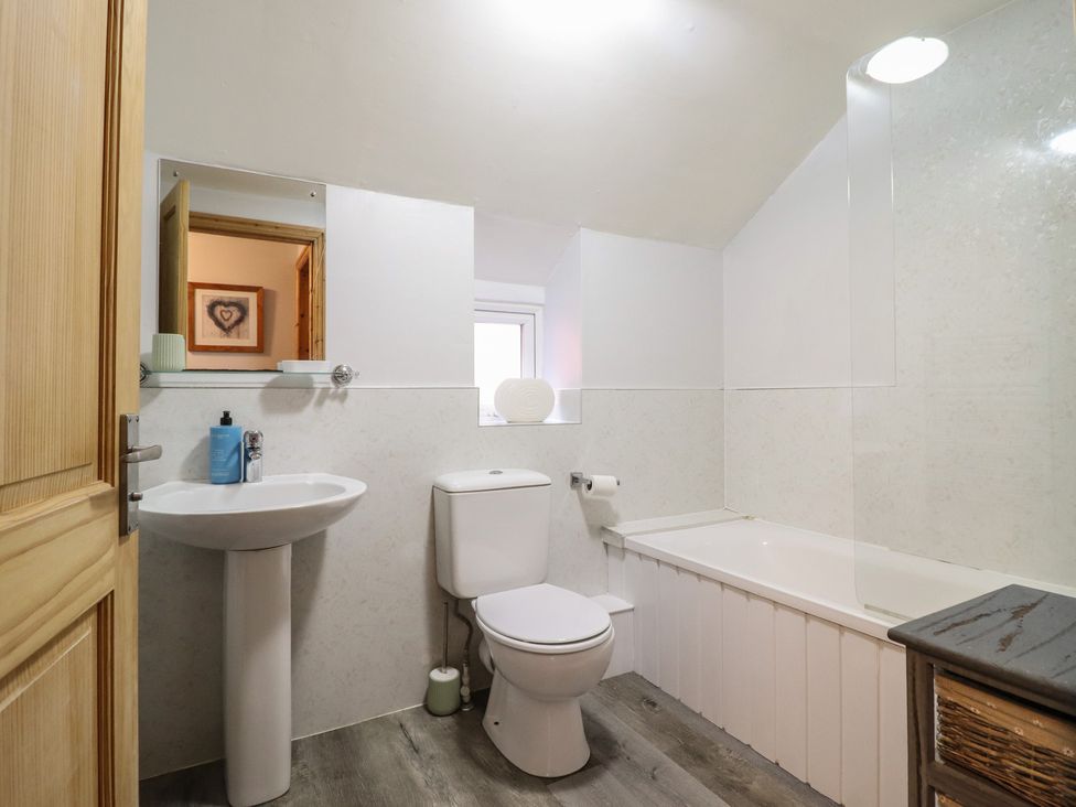 A bathroom with a wash basin, toilet, and bathtub at Bridgeway House in Blaenau Ffestiniog