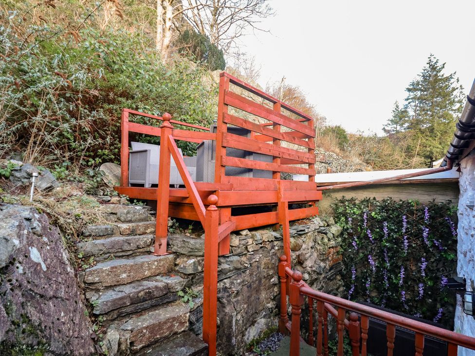 A deck area with outdoor furniture and a staircase at Bridgeway House in Blaenau Ffestiniog