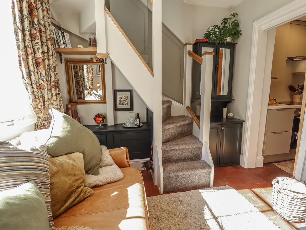 A living room with a staircase and sofa at Hangmans cottage in Horncastle