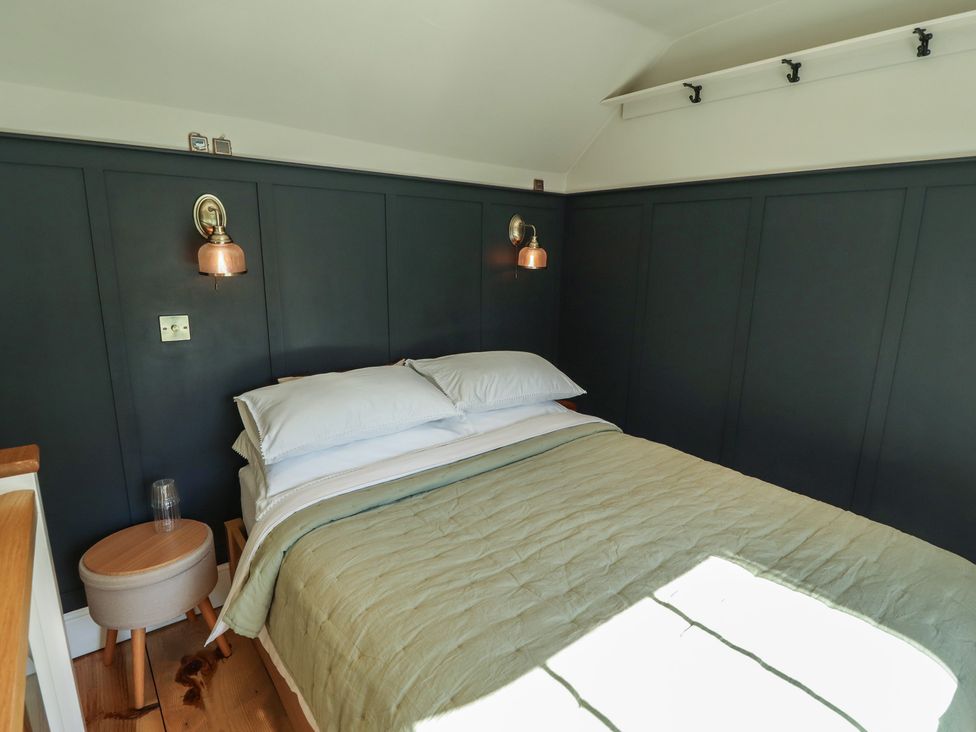 A bedroom with a bed and a bedside table at Hangmans cottage Horncastle