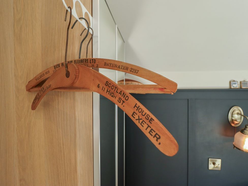 A wooden wardrobe with coat hangers at Hangmans cottage in Horncastle