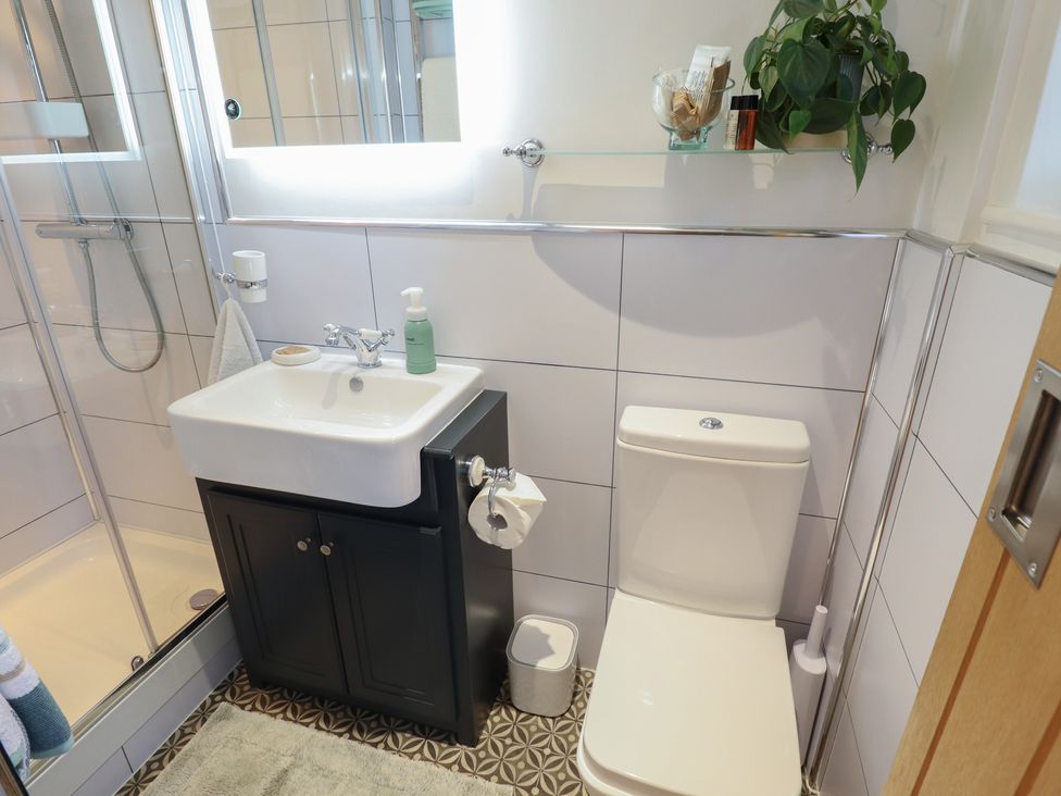 A bathroom featuring a sink, toilet, and shower at Hangmans cottage in Horncastle