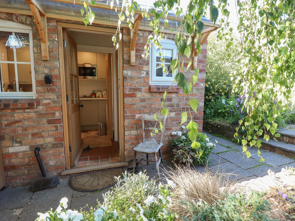 An entrance with a chair and plants at Hangmans cottage Horncastle