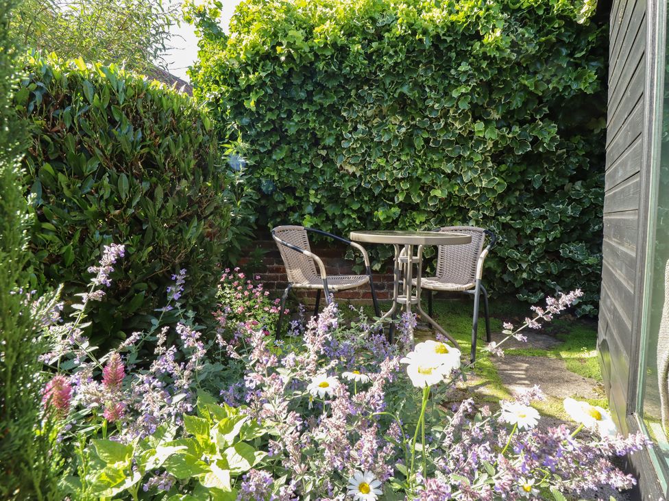 A table with chairs surrounded by flowers at Hangmans cottage Horncastle