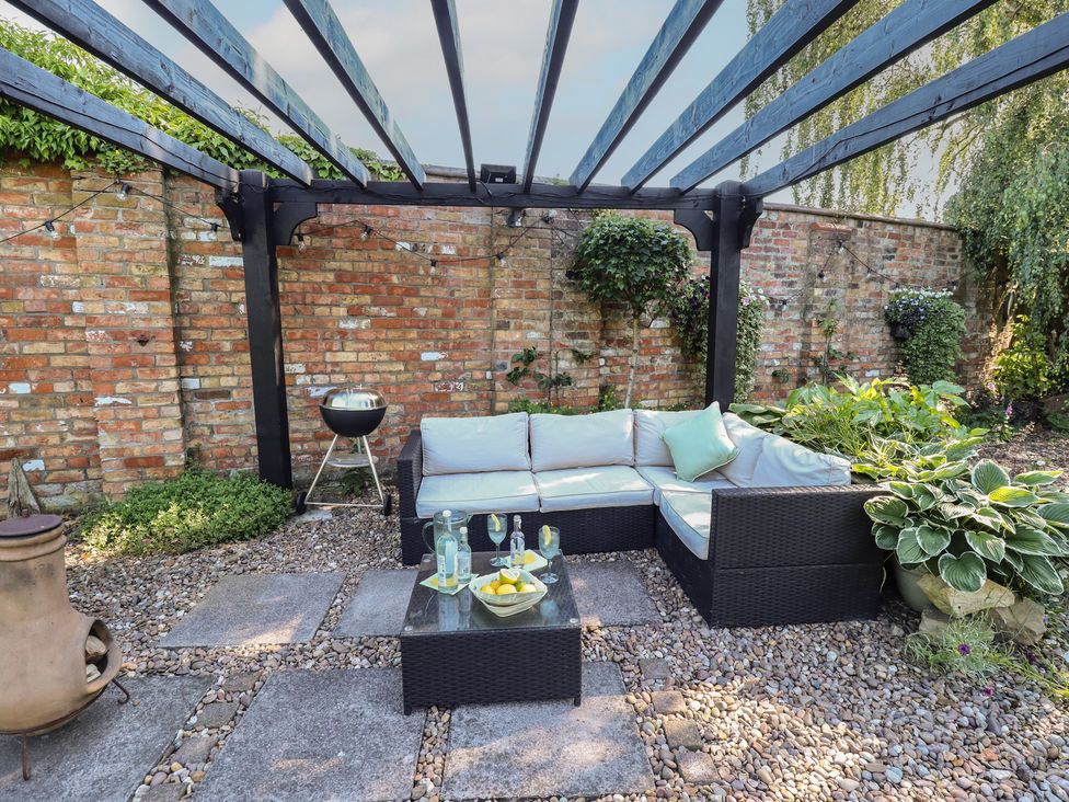 A garden with seating area and a grill at Hangmans cottage Horncastle