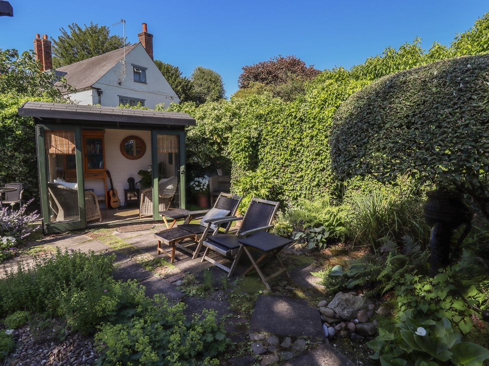 A garden with a shed and deckchairs at Hangmans cottage in Horncastle