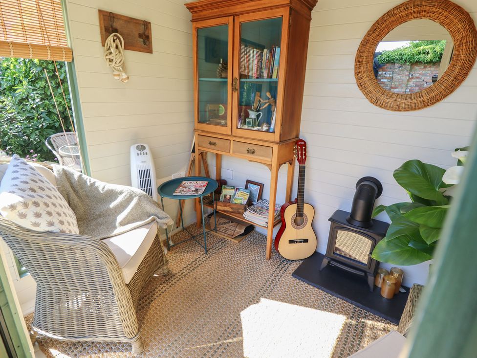 A snug with a chair and a guitar at Hangmans cottage in Horncastle