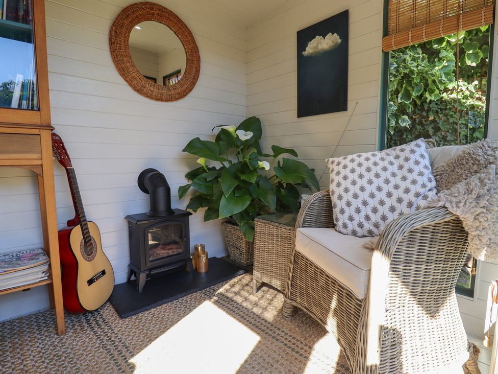 A snug area with a guitar and fireplace at Hangmans cottage Horncastle