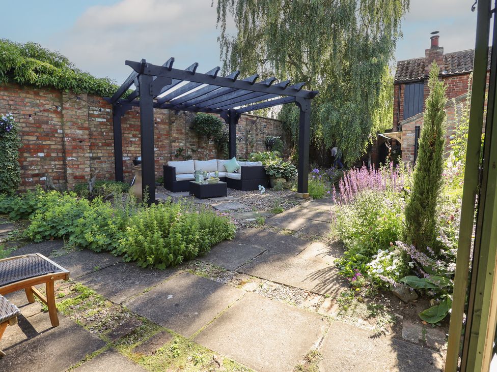A garden with a terrace seating area at Hangmans cottage Horncastle