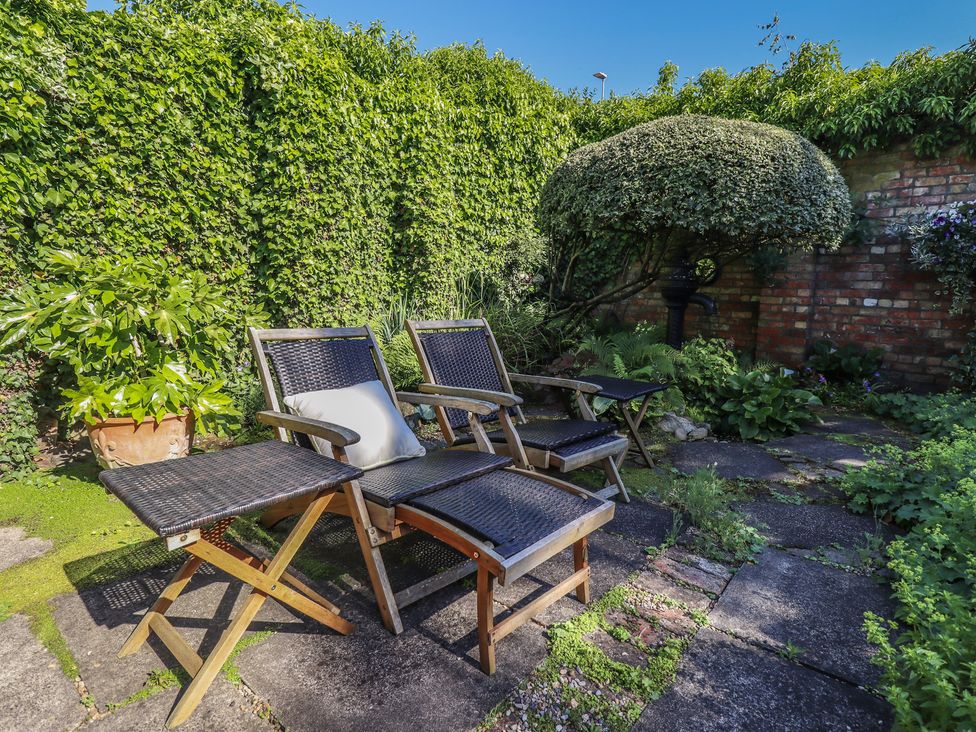 A garden with chairs and plants at Hangmans cottage in Horncastle