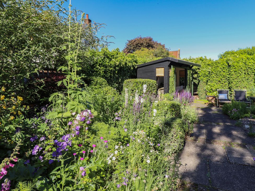 A garden with a shed and seating area at Hangmans cottage Horncastle