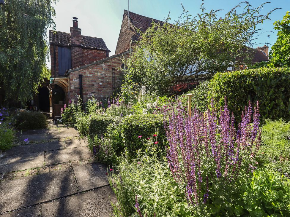 A garden with flowers and a pathway at Hangmans cottage in Horncastle