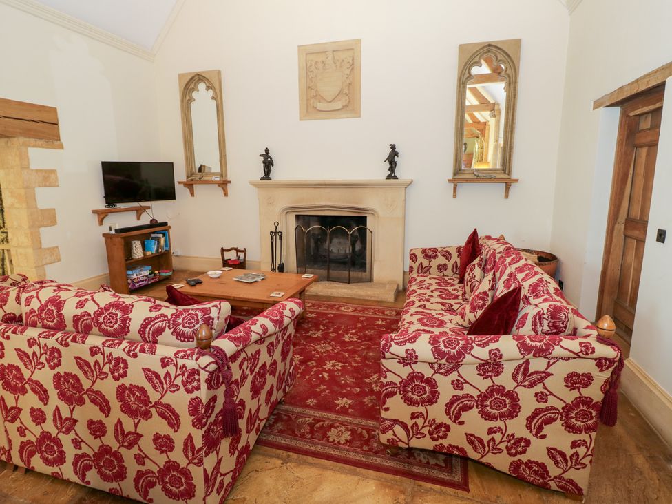 A living room with sofas, a fireplace, and a television at Rookery Hall near Broadway