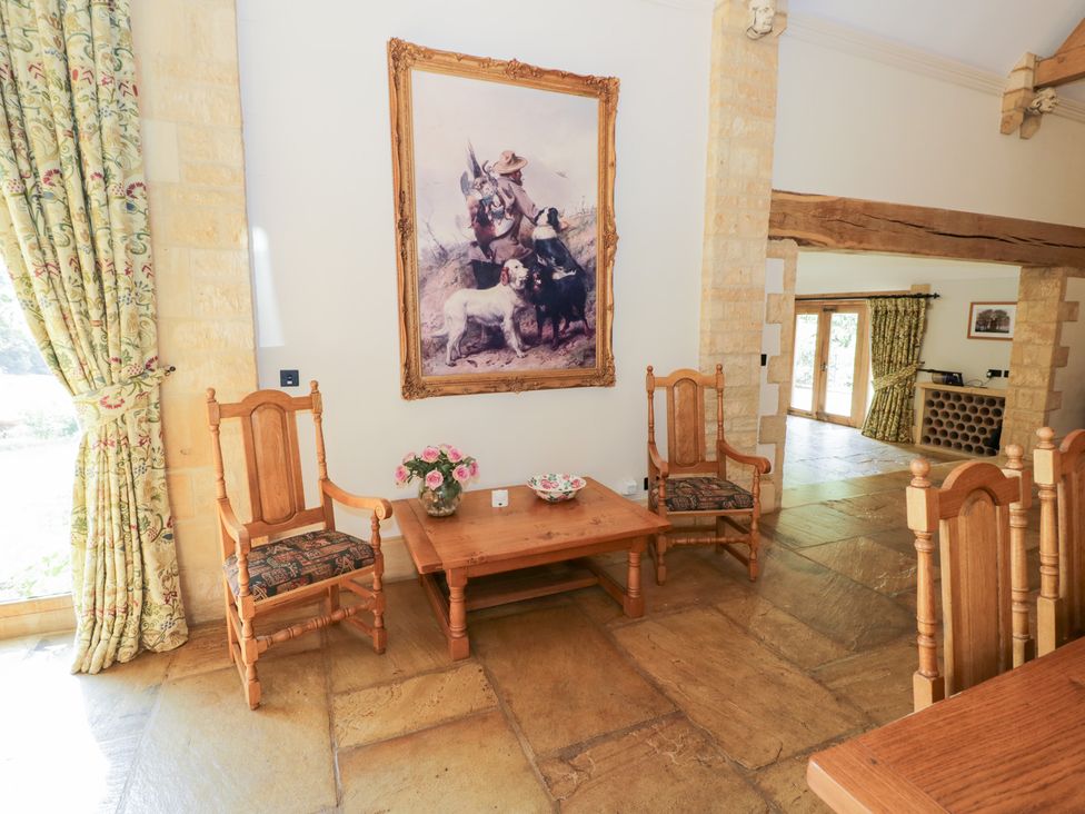 A living room with chairs, a table, and a painting at Rookery Hall Middle Hill near Broadway
