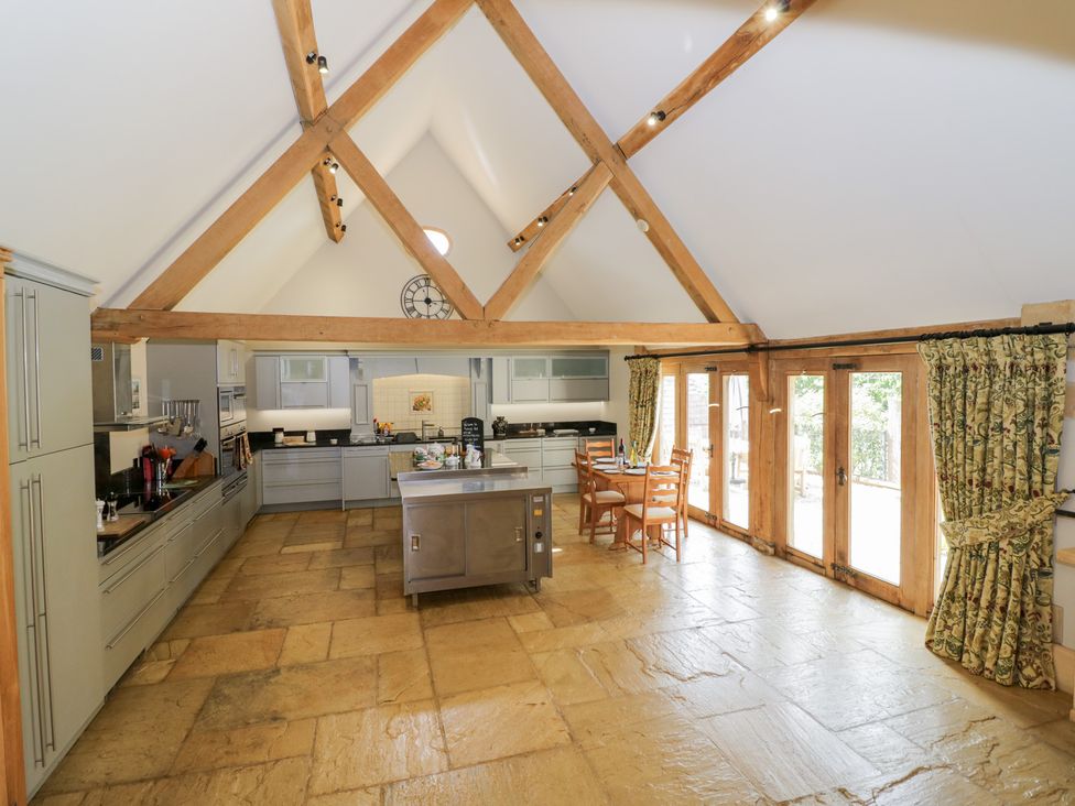 A kitchen with an island and dining area at Rookery Hall in Middle Hill near Broadway
