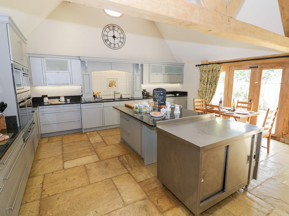 A kitchen with stainless steel island and dining table at Rookery Hall in Middle Hill near Broadway
