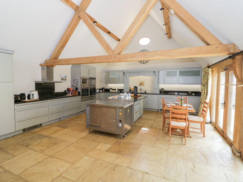 A kitchen with a central island and dining area at Rookery Hall in Middle Hill near Broadway