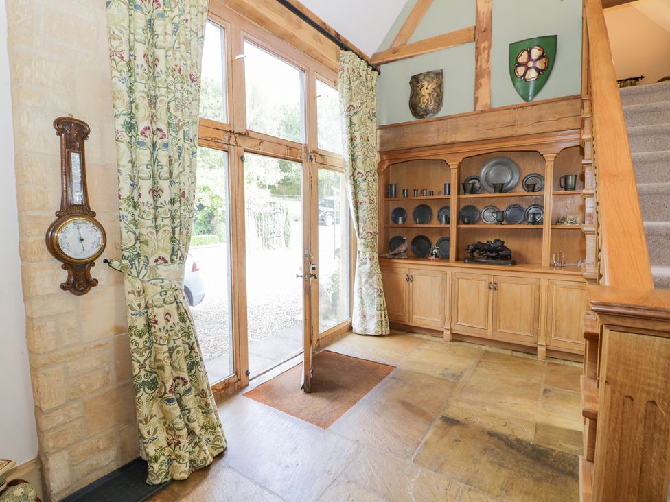 An entrance hall with a clock and shelf displaying plates at Rookery Hall near Middle Hill