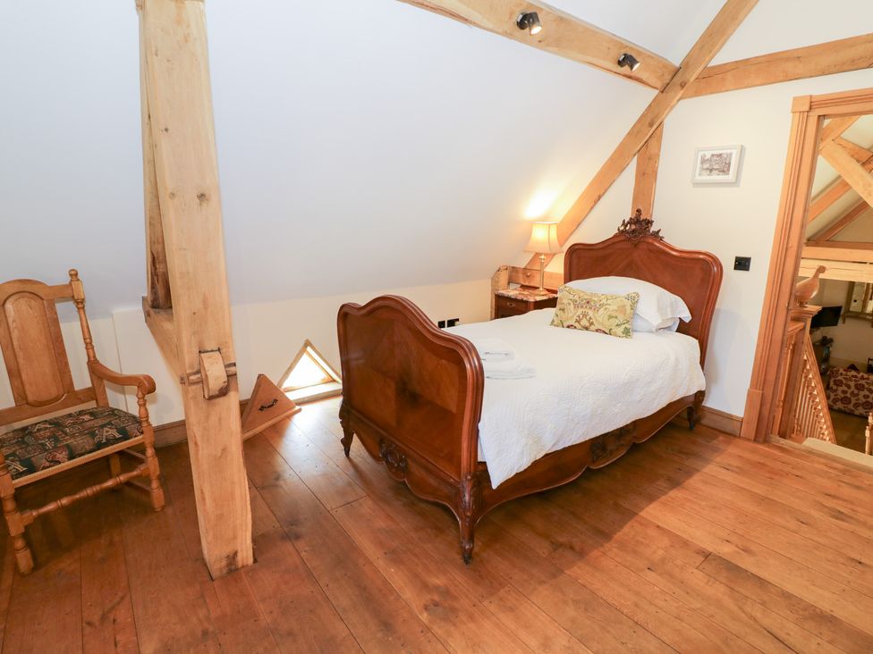 A bedroom with a bed and chair at Rookery Hall in Middle Hill near Broadway