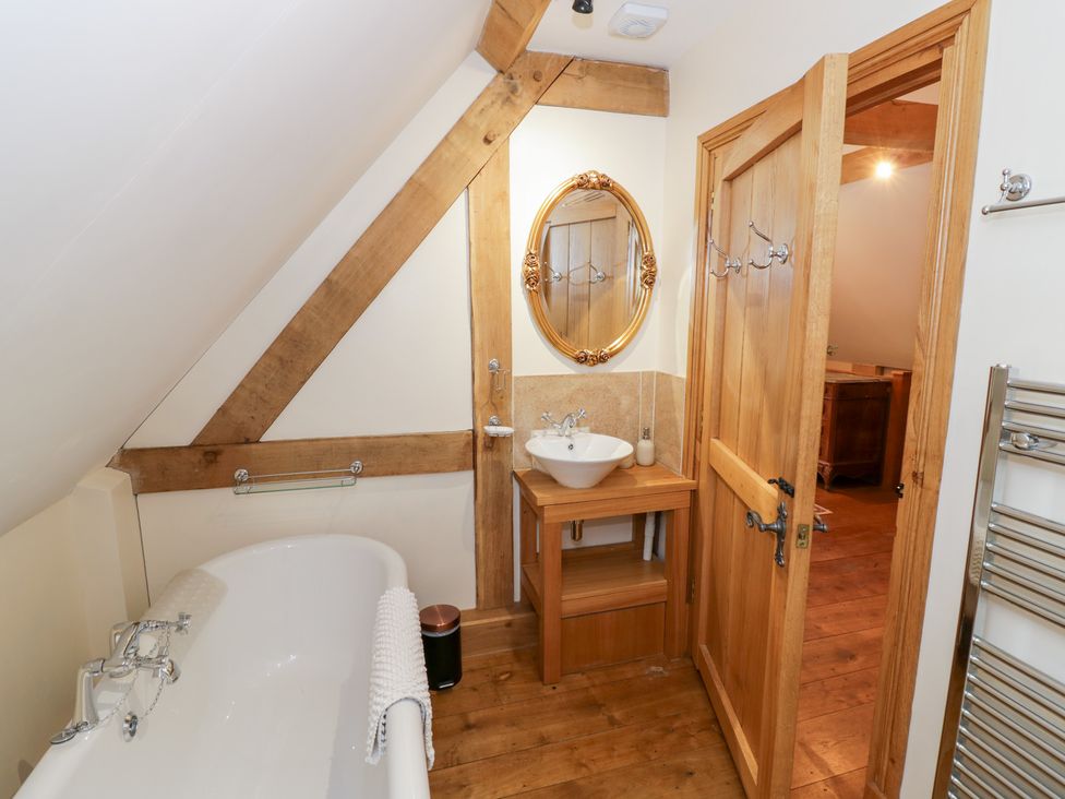 A bathroom with a bathtub and a hand basin at Rookery Hall in Middle Hill near Broadway
