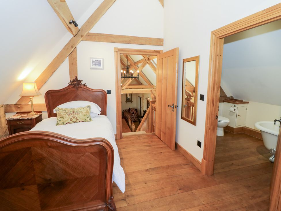 A bedroom with a bed and a doorway to a bathroom at Rookery Hall Middle Hill near Broadway
