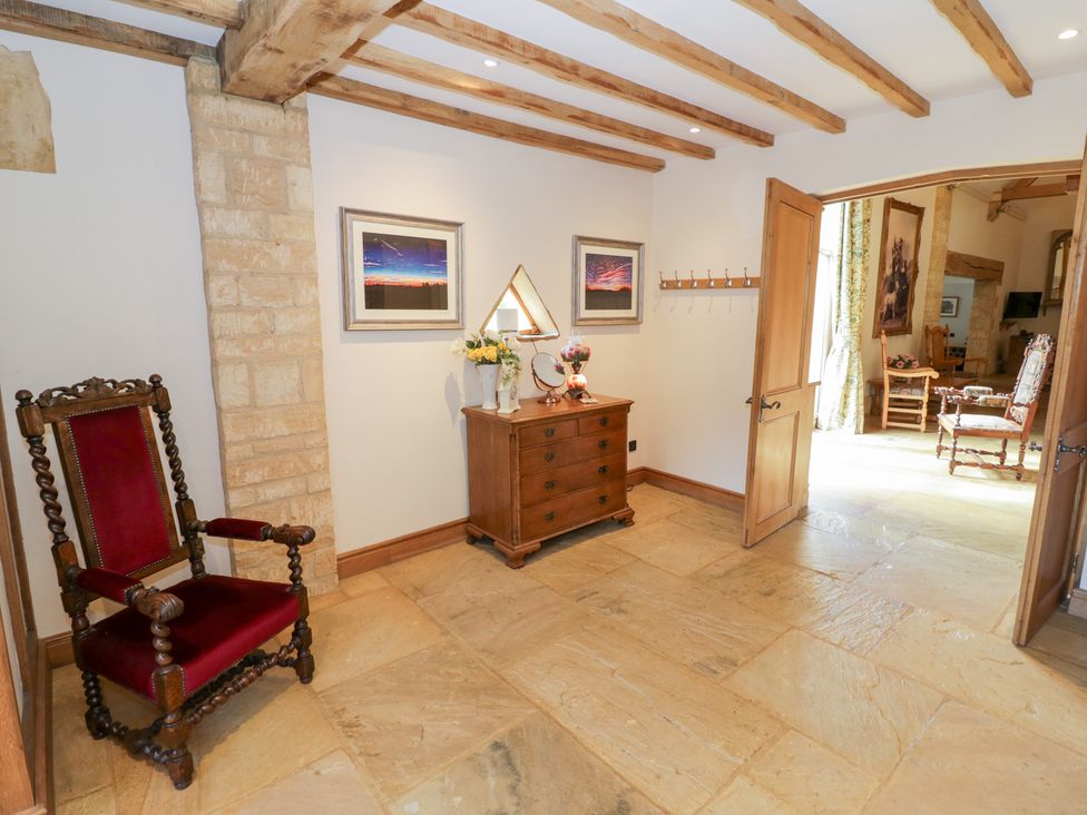 A hallway with a chair and a table at Rookery Hall in Middle Hill near Broadway