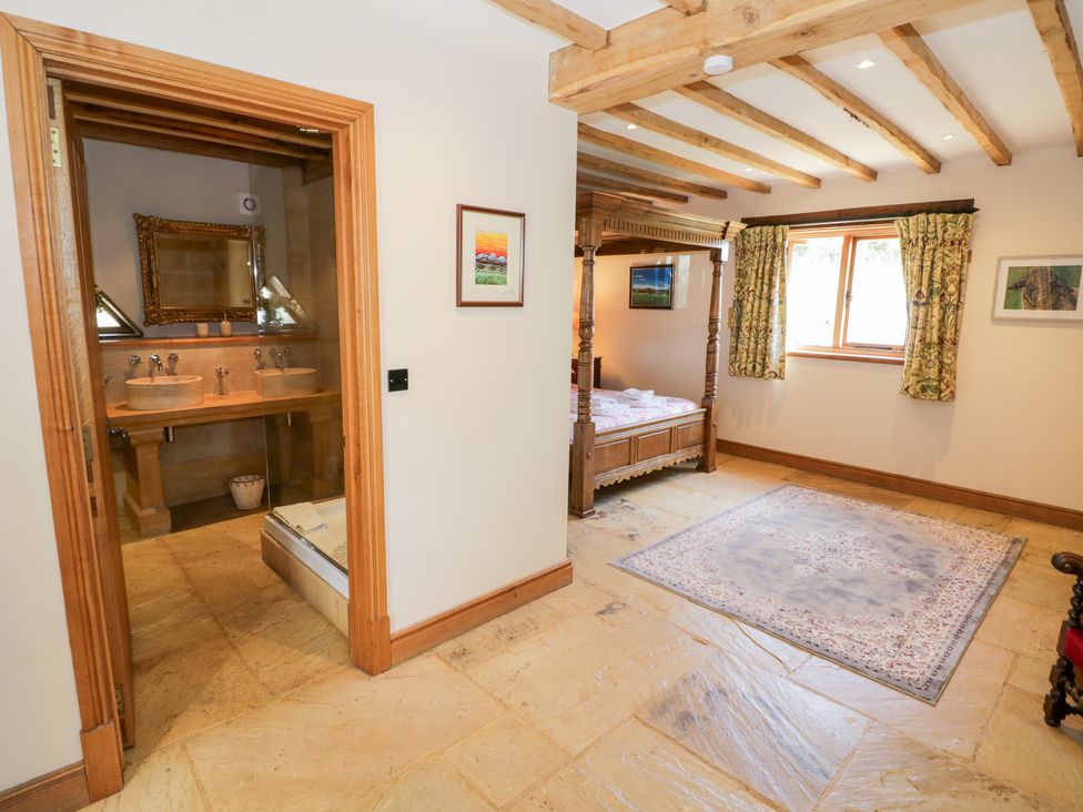 A bedroom with a bed and an adjacent bathroom at Rookery Hall in Middle Hill near Broadway