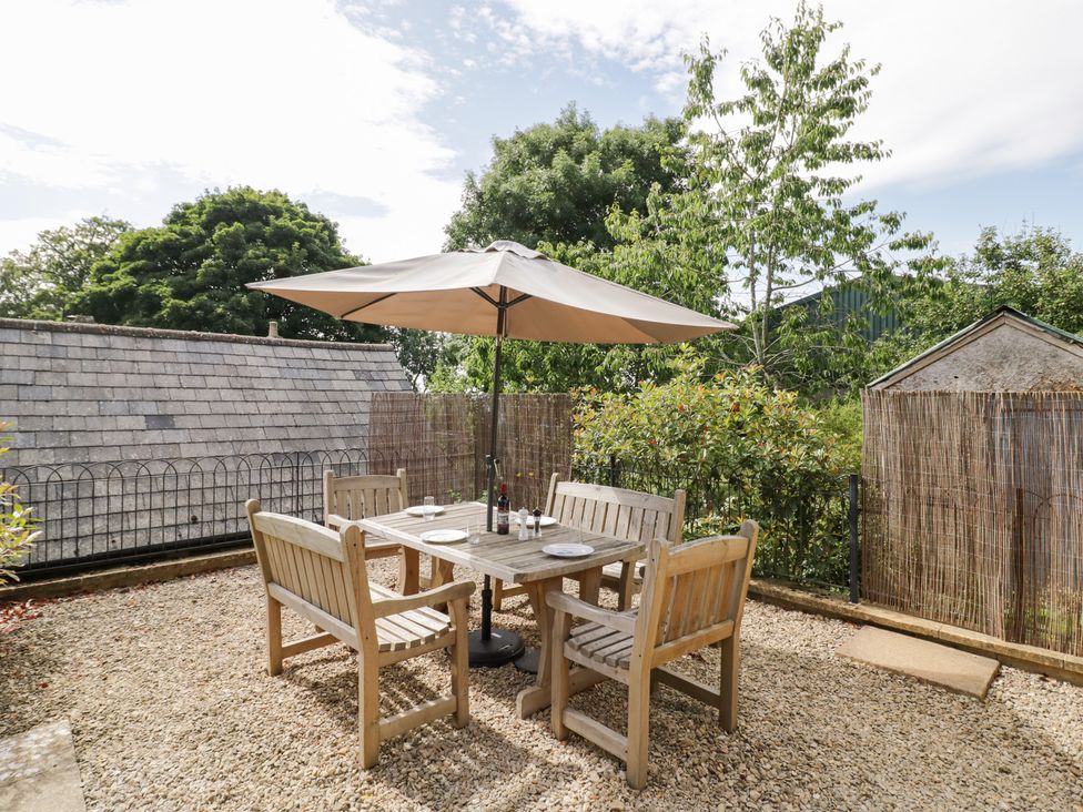 A garden with a seating area and umbrella at Rookery Hall in Middle Hill near Broadway
