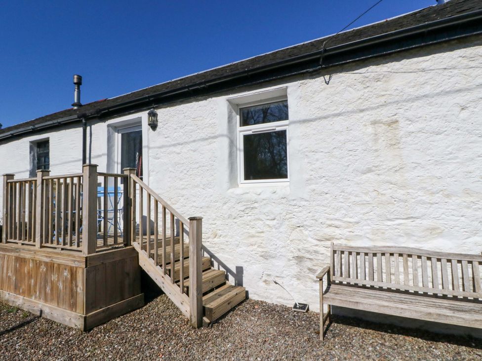 An outdoor area with wooden decking and a bench at Gun Powder Cottage in Tighnabruaich