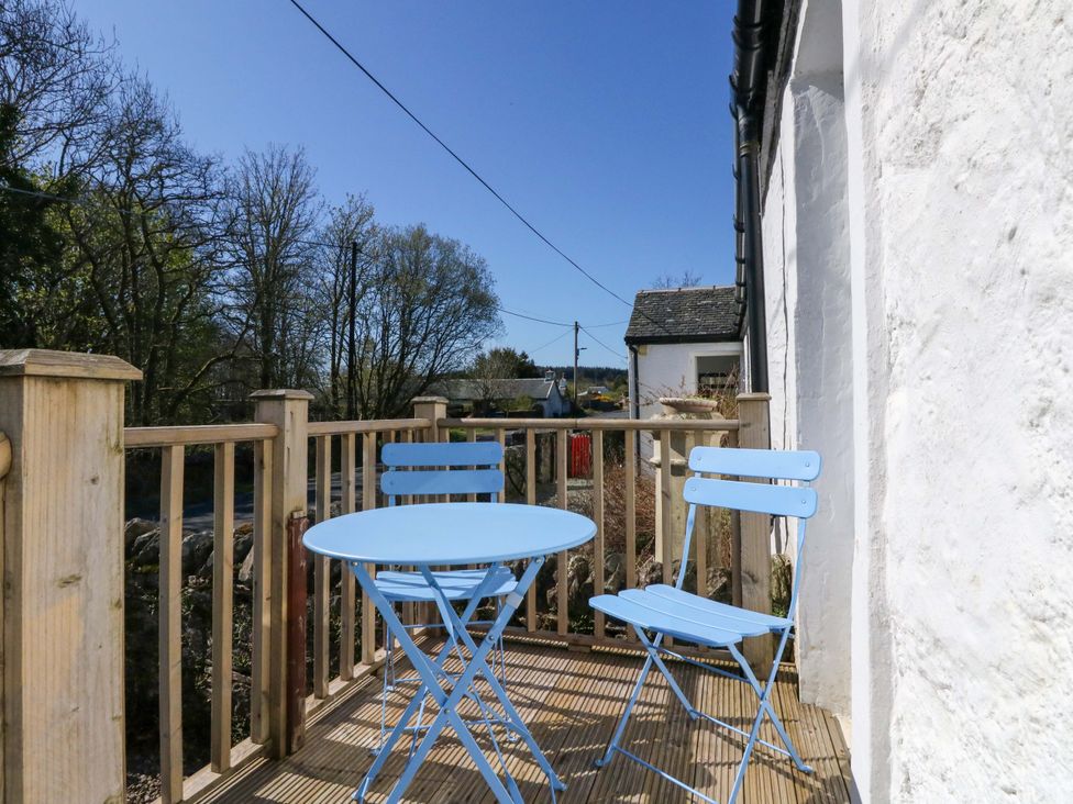 A blue table and chairs on a balcony at Gun Powder Cottage Tighnabruaich