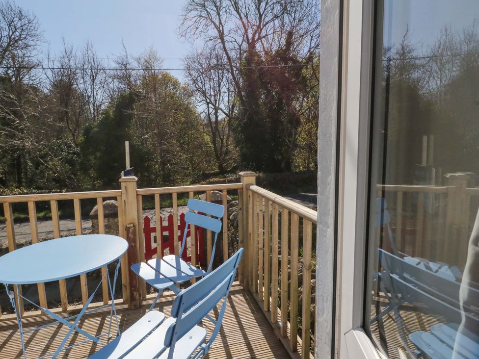 A balcony with a table and chairs at Gun Powder Cottage in Tighnabruaich