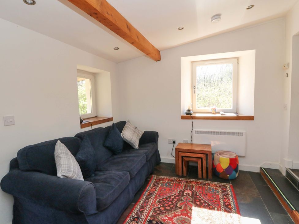 A living room with a sofa and a table at Gun Powder Cottage Tighnabruaich