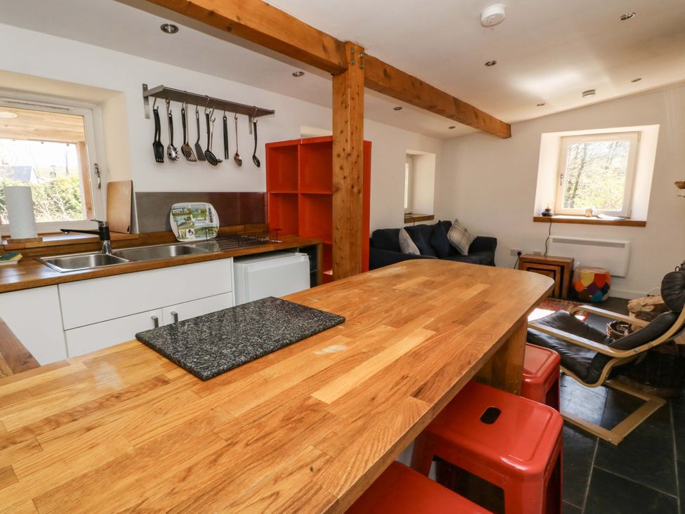 A kitchen with a countertop and seating at Gun Powder Cottage Tighnabruaich