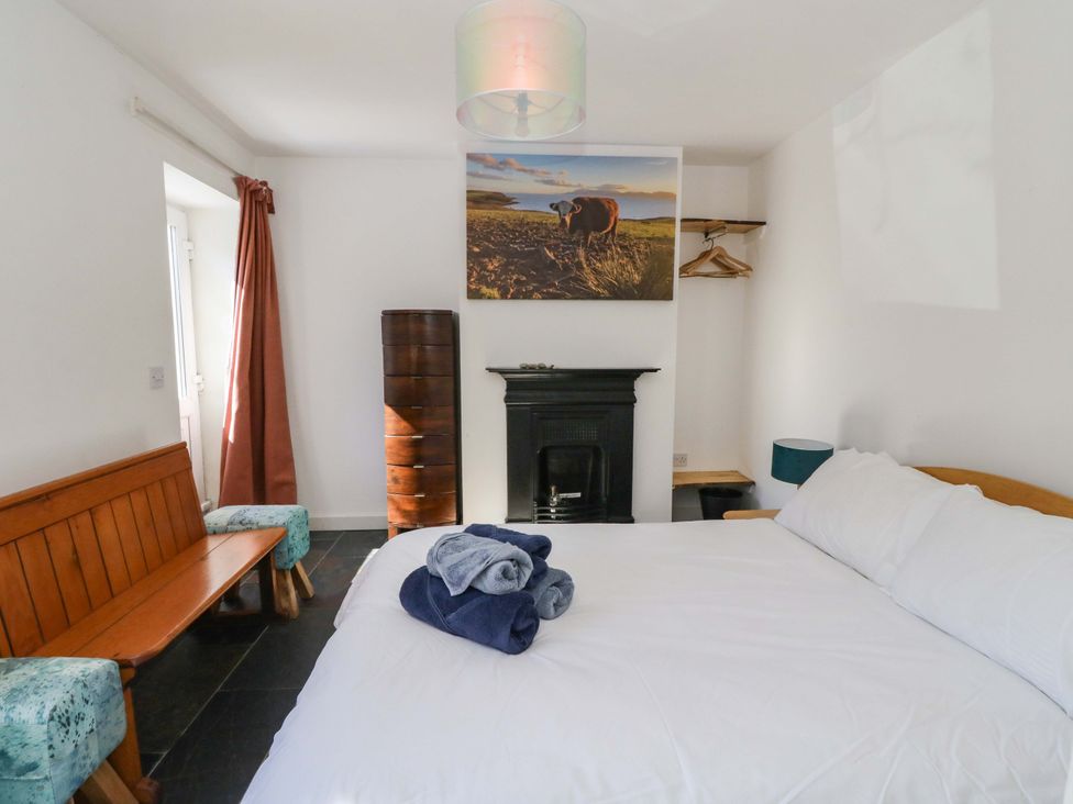 A bedroom with a bed and sofa at Gun Powder Cottage in Tighnabruaich
