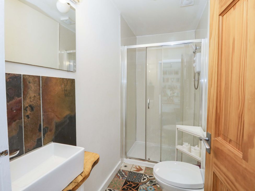 A bathroom with a shower, sink, and toilet at Gun Powder Cottage Tighnabruaich