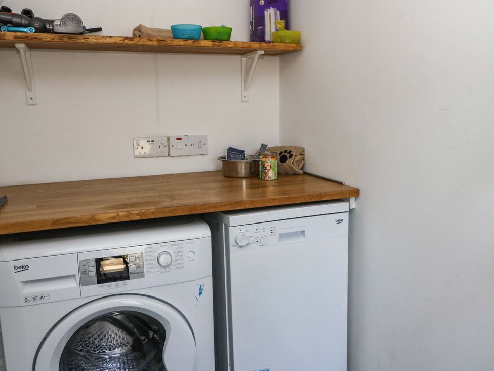A laundry room with a washing machine and dishwasher at Gun Powder Cottage in Tighnabruaich