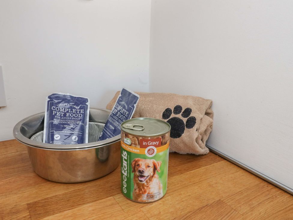 A pet area with food supplies including bowls and dog food at Gun Powder Cottage Tighnabruaich