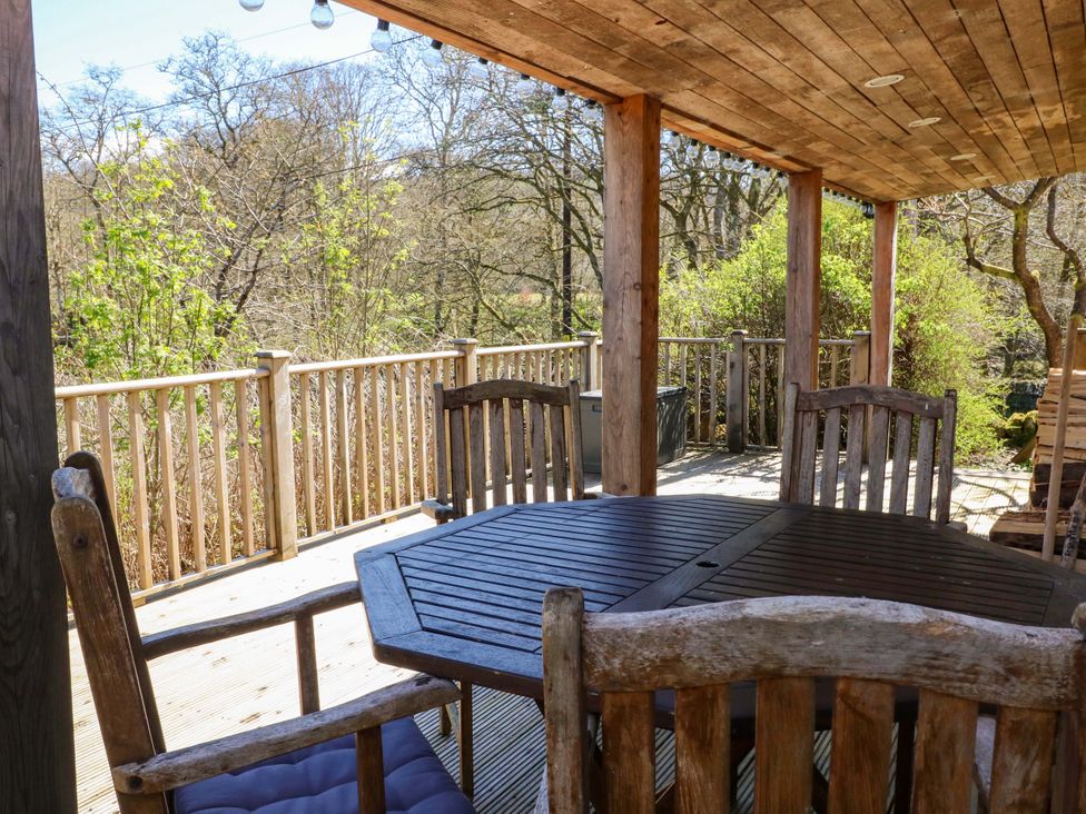 A wooden table and chairs on a deck area at Gun Powder Cottage Tighnabruaich