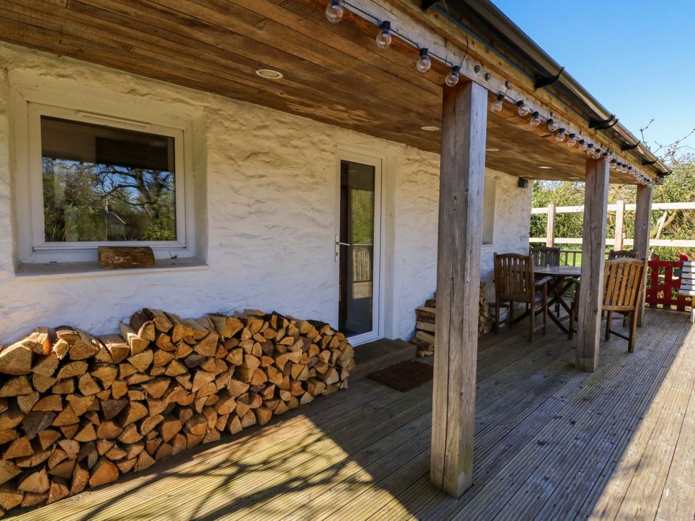 An outdoor patio with a table and chairs at Gun Powder Cottage in Tighnabruaich